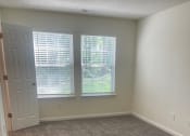 Thumbnail 64 of 78 - a carpeted room with two windows and a door