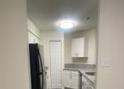Thumbnail 77 of 78 - a kitchen with white cabinets and a black refrigerator