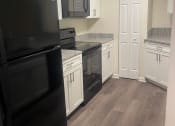 Thumbnail 68 of 78 - a kitchen with white cabinets and black appliances