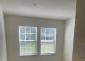 Thumbnail 61 of 78 - an empty room with two windows and a carpeted floor