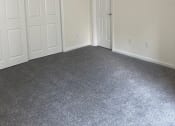 Thumbnail 66 of 78 - a bedroom with two doors and a carpeted floor