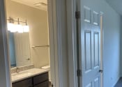 Thumbnail 56 of 78 - a doorway into a bathroom with a sink and a mirror
