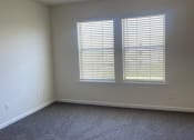 Thumbnail 48 of 78 - an empty living room with two windows and carpet