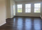 Thumbnail 52 of 78 - an empty living room with wood floors and a ceiling fan