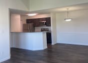 Thumbnail 51 of 78 - an empty living room with a ceiling fan and a kitchen