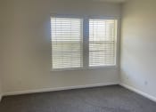 Thumbnail 54 of 78 - an empty living room with two windows and carpet