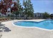 Thumbnail 70 of 78 - a swimming pool and a resort style pool with trees and buildings in the background