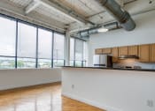 Thumbnail 8 of 46 - an empty room with a large window and a kitchen at The Hudson, Richmond, 23224