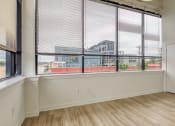 Thumbnail 36 of 46 - an empty room with a large window with blinds and a white door  at The Hudson, Richmond