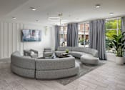 Thumbnail 9 of 42 - A modern living room with a grey sofa set and a television on the wall.