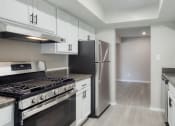 Thumbnail 43 of 52 - a kitchen with white cabinets and stainless steel appliances  at Bayville Apartments, Virginia Beach, Virginia