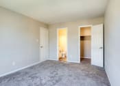 Thumbnail 47 of 52 - a living room with carpet and a door to a bedroom  at Bayville Apartments, Virginia Beach, 23455