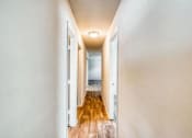 Thumbnail 13 of 24 - a long hallway with doors and a lamp on the ceiling at Gates of West Bay, Norfolk, VA