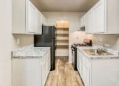 Thumbnail 8 of 24 - a kitchen with white cabinets and a black refrigerator at Gates of West Bay, Norfolk Virginia