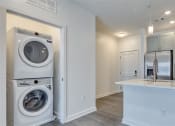 Thumbnail 20 of 47 - a laundry room with a washer and dryer and a kitchen at The Port at East Beach Apartments and Marina, Norkfolk