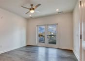 Thumbnail 24 of 47 - an empty living room with a ceiling fan and large windows at The Port at East Beach Apartments and Marina, Norkfolk