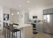 Thumbnail 19 of 47 - a white kitchen with a island and stainless steel refrigerator at The Port at East Beach Apartments and Marina, Norkfolk, VA