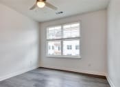 Thumbnail 26 of 47 - an empty bedroom with a ceiling fan and a window at The Port at East Beach Apartments and Marina, Virginia, 23518