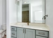 Thumbnail 28 of 47 - a bathroom with a sink toilet and a mirror at The Port at East Beach Apartments and Marina, Norkfolk, VA