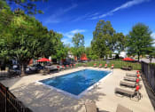 Thumbnail 2 of 32 - a swimming pool with chaise lounge chairs and umbrellas at Addison Crater Woods, Petersburg Virginia