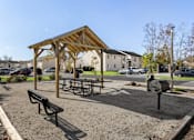 Thumbnail 18 of 21 - a picnic area with benches and a grill