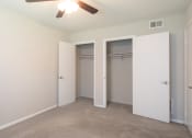 Thumbnail 15 of 16 - a bedroom with a ceiling fan and two closets