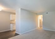 Thumbnail 12 of 16 - an empty living room with a kitchen in the background