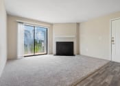 Thumbnail 19 of 43 - an empty living room with a fireplace and sliding glass doors at Village 1373, Greensboro