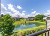 Thumbnail 38 of 43 - a view of a pond with apartments in the background at Village 1373, Greensboro, 27455