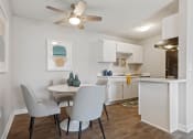 Thumbnail 6 of 43 - a dining room and kitchen with white cabinets and a ceiling fan at Village 1373, Greensboro, NC