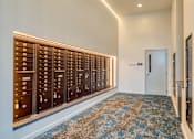 Thumbnail 29 of 40 - A hallway with a row of mailboxes on the wall.
