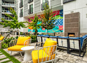 Thumbnail 7 of 40 - A patio with yellow chairs and a fireplace.
