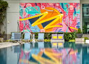 Thumbnail 9 of 40 - A pool with a mural on the wall behind it.