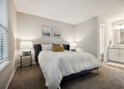 Thumbnail 16 of 44 - a bedroom with a bed and a bathroom in the background at Wendover River Oaks, Greensboro, NC