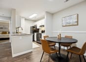 Thumbnail 13 of 44 - a dining area with a table and chairs and a kitchen in the background at Wendover River Oaks, Greensboro, North Carolina