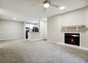 Thumbnail 29 of 44 - a living room with a fireplace and a kitchen in the background at Wendover River Oaks, North Carolina