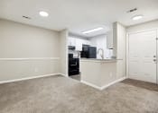Thumbnail 31 of 44 - a spacious living room with a kitchen in the background at Wendover River Oaks, Greensboro
