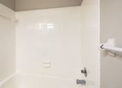 Thumbnail 51 of 52 - a white bathroom with a tub and a shower curtain at Bayville Apartments, Virginia, 23455