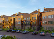 Thumbnail 45 of 51 - a row of apartment buildings with cars parked in front of them at Terraces at High Mountain, Alabama