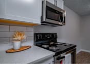 Thumbnail 10 of 18 - A modern kitchen with a stove, oven, and microwave.