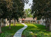 Thumbnail 11 of 16 - A pathway leads through a grassy area to a building.