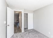 Thumbnail 13 of 16 - A room with a white door and a carpeted floor.