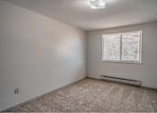 Thumbnail 7 of 18 - A room with a window and a carpeted floor.