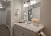 Thumbnail 11 of 13 - A bathroom with a white counter top and a white sink.