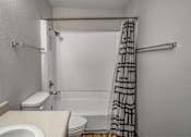 Thumbnail 12 of 18 - A white toilet sits next to a sink in a small bathroom.