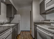 Thumbnail 6 of 18 - A kitchen with a stove, oven, and refrigerator.