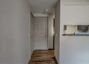 Thumbnail 13 of 18 - A white door is in a hallway with wood floors.