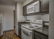 Thumbnail 15 of 18 - A kitchen with a stove, oven, and microwave.