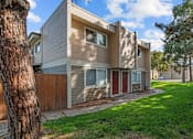 Thumbnail 7 of 15 - A modern two-story house with a red door and a brown fence.