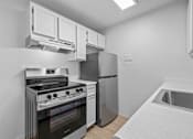Thumbnail 15 of 15 - A modern kitchen with a stove, oven, and refrigerator.